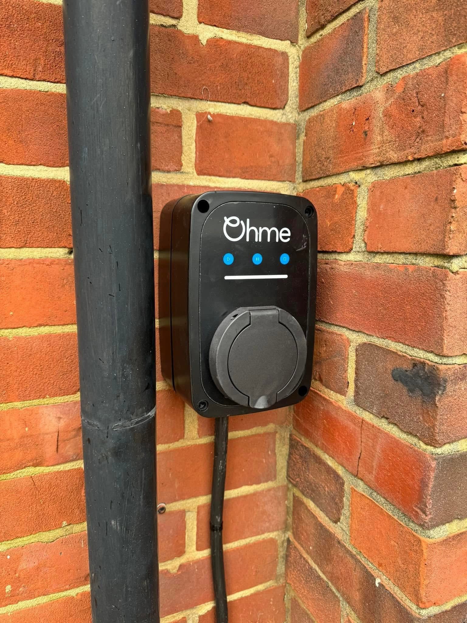 Ohme EV charger installed on brick wall