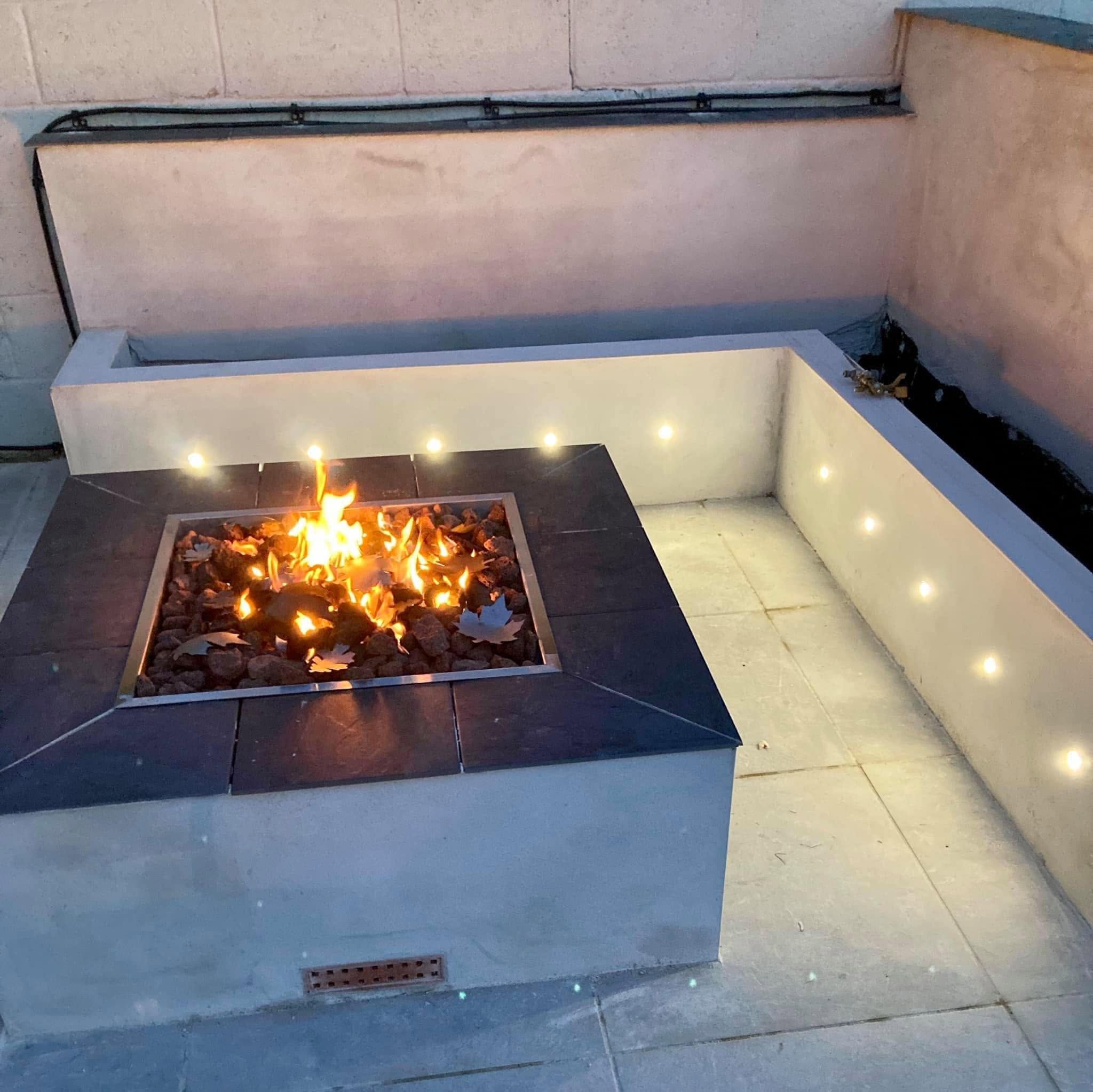 Outdoor gas fire pit with LED lighting