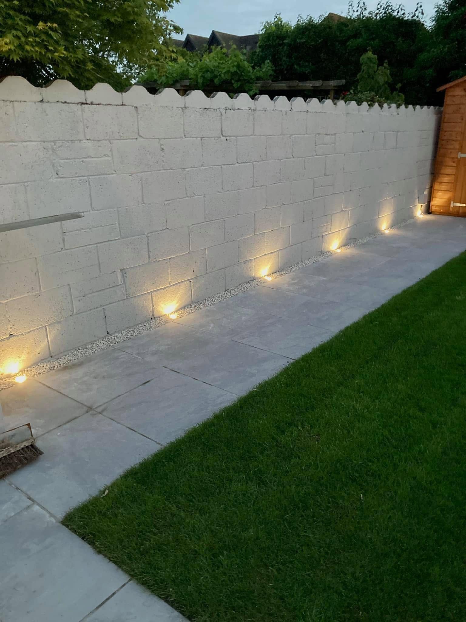 Garden wall with ground level uplighting at dusk