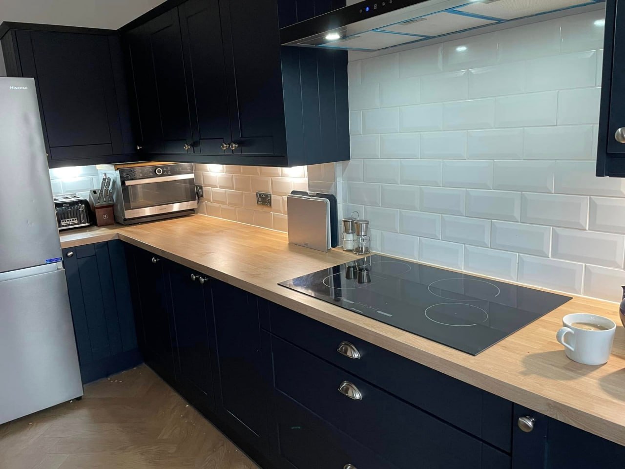 Navy kitchen with wood effect worktop and induction hob
